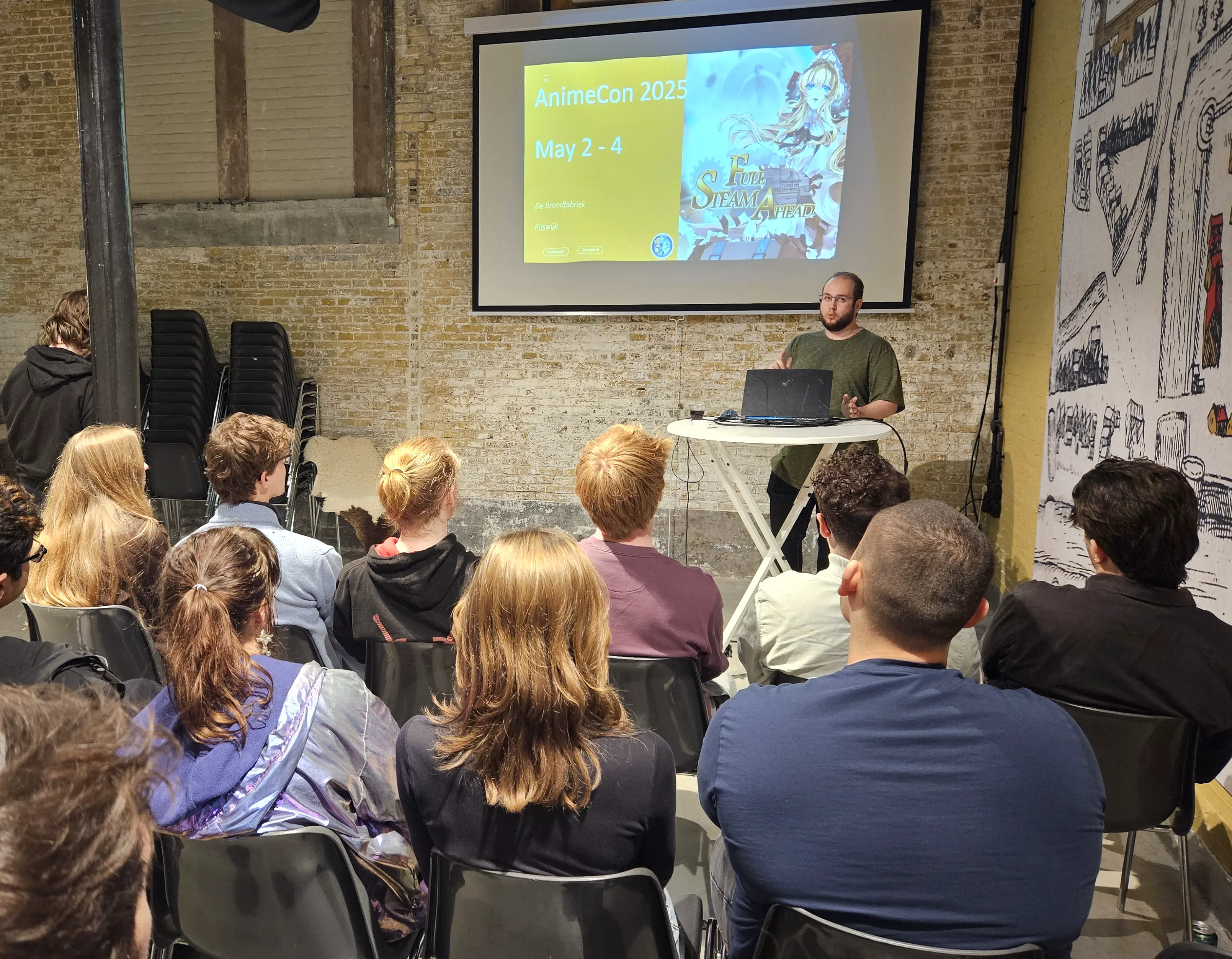 Photo taken during the Open Dev Mix, a man is presenting in front of an audience