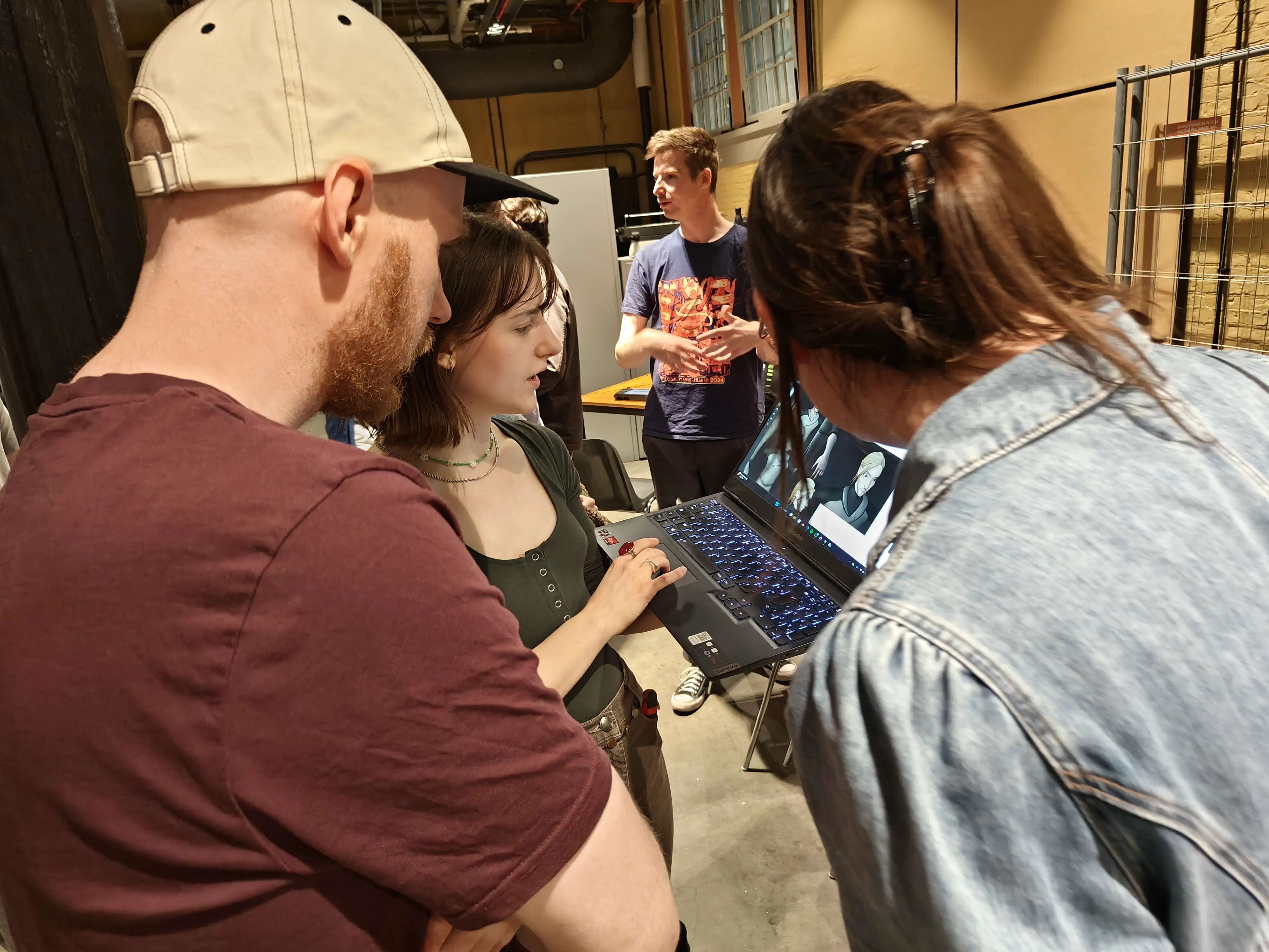 Photo taken during the Open Dev Mix, a woman is showing her work on her laptop to two people